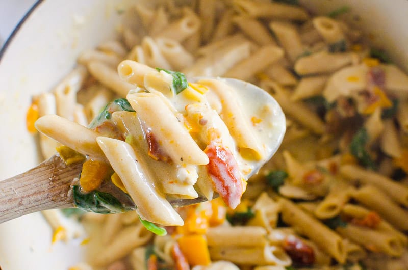 Tuscan chicken pasta on a spoon.