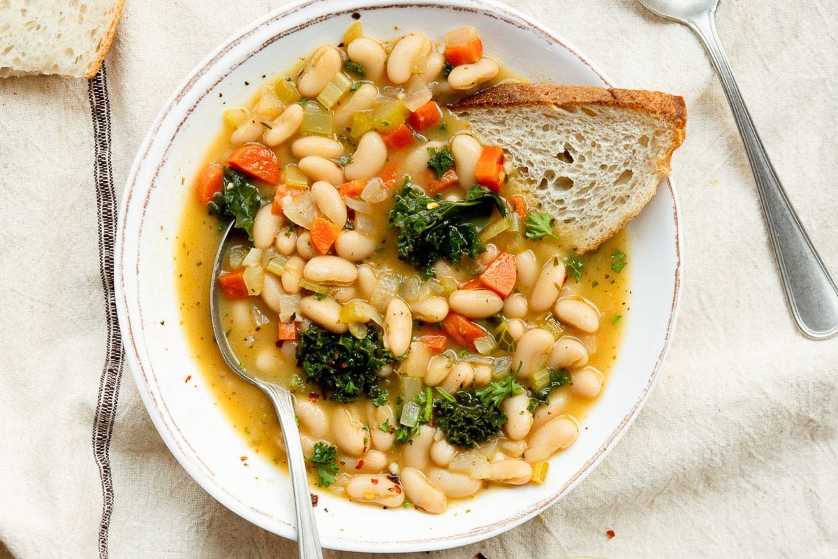 Looking down on a bowl of soup with bread.