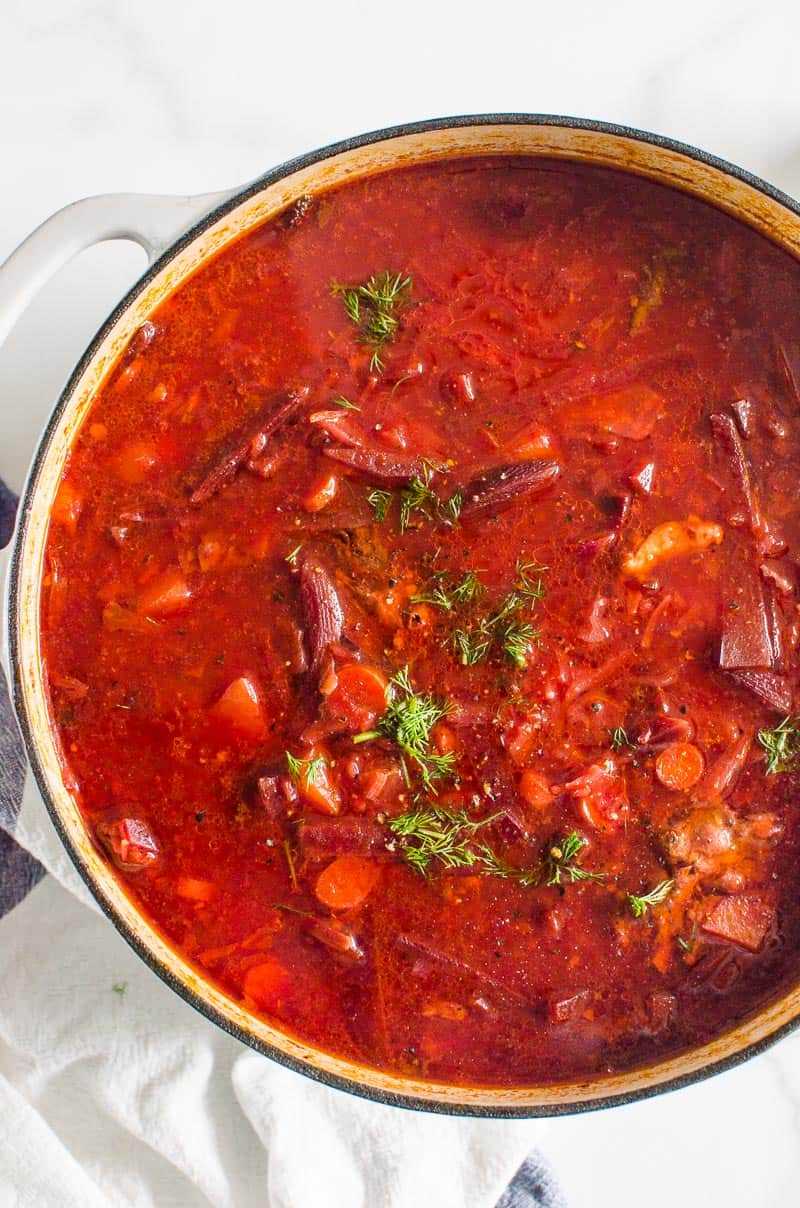 Borscht in white pot garnished with dill.