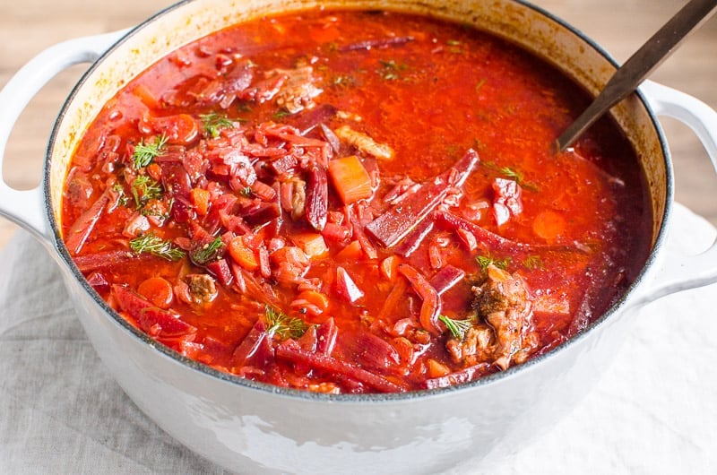 Ukrainian borscht in white pot with ladle.
